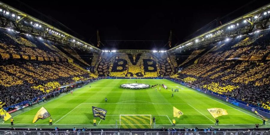 Die Dortmunder Fans zeigen vor Beginn des Spiels im Signal Iduna Park eine Choreogephie die über 3 Tribünen. Foto: Guido Kirchner/dpa