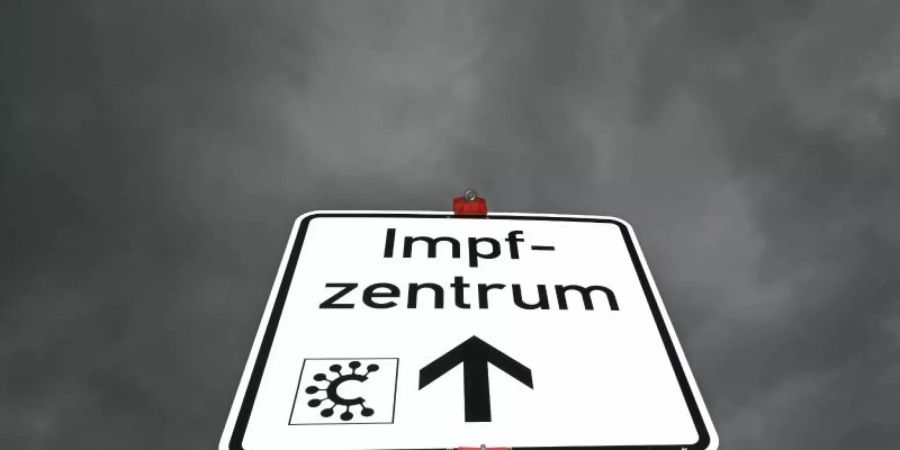 Ein Hinweisschild mit der Aufschrift «Impfzentrum» und einem Covid-Logo ist nahe des Impfzentrums Heuchelheim zu sehen. Foto: Arne Dedert/dpa