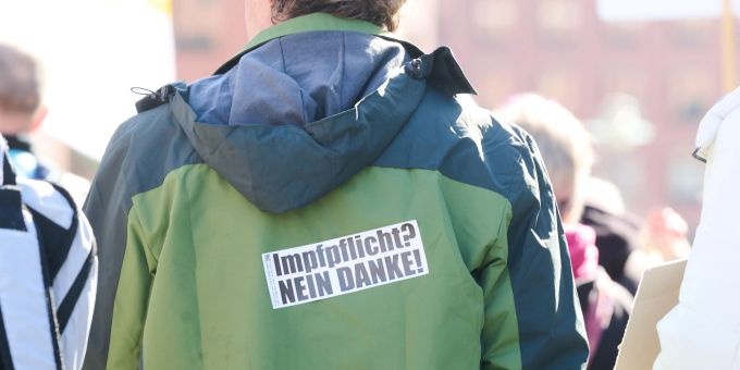 «Impfpflicht? Nein Danke!» steht auf dem Rücken eines Demonstranten auf dem Potsdamer Platz in Berlin. Impfpflicht Verstöße
