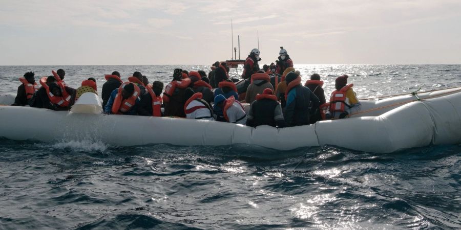 Menschen in einem in Not geratenen Schlauchboot, die von der Rettungsmannschaft «Sea-Watch 3» an Bord genommen werden. (Archivbild)