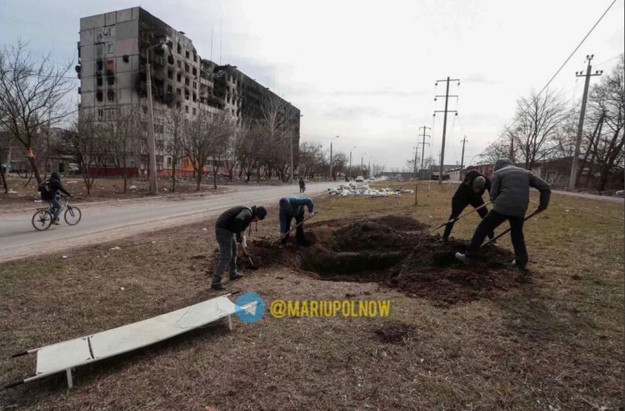 Neue Gräber werden in der Stadt Mariupol auf Grünflächen gegraben.