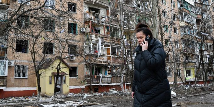 Eine Frau telefoniert am 6. März 2022, während sie nach dem Beschuss im Ukraine-Krieg durch die russischen Streitkräfte an einem beschädigten Wohnhaus in Kramatorsk vorbeigeht. Ukraine Krieg Kramatorsk