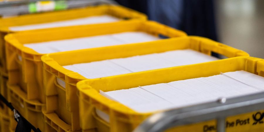 Sendungen des Zensus 2022 liegen im Briefzentrum Offenburg der Deutschen Post in Logistikbehältern.