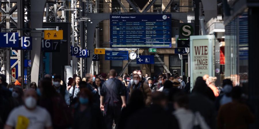 Reisende gehen durch die Bahnhofshalle in Frankfurt/Main. Die Debatte um die Maskenpflicht in öffentlichen Transportmitteln geht weiter.