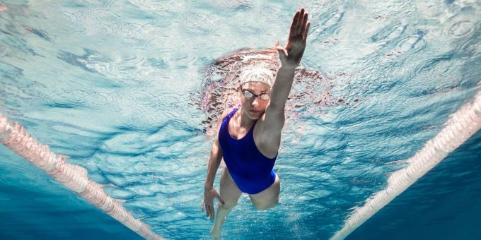 Um effektiv zu schwimmen, gibt es ein paar Dinge zu beachten. Frau schwimmt
