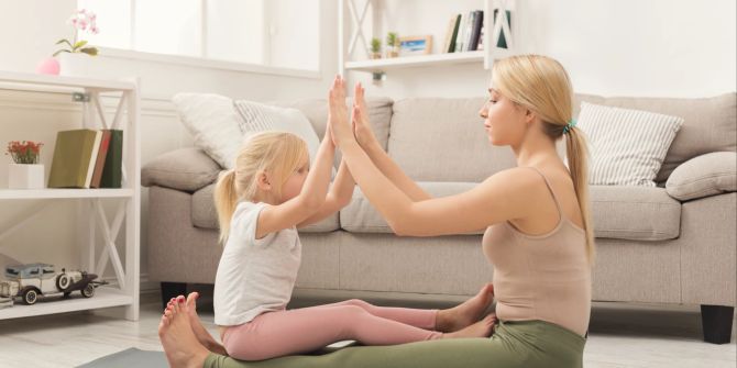 Mutter mit Kind auf Yoga-Matte
