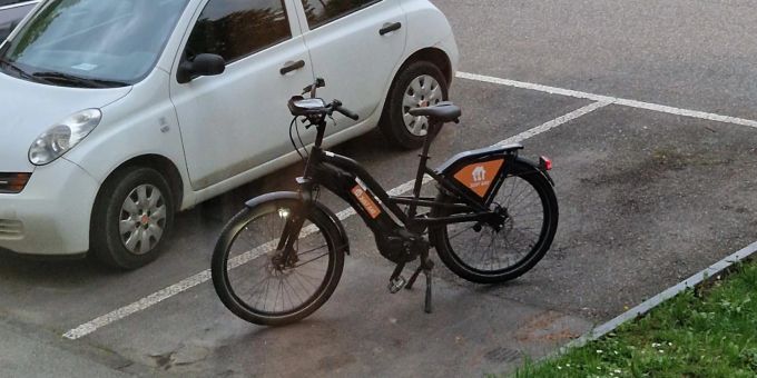 Das Velo eines Just-Eat-Kuriers steht mitten auf einem Parkplatz. velo