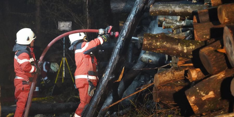 Die Feuerwehr Embrachertal im Kampf gegen die Glutherde nach dem Brand des Holzhaufens.