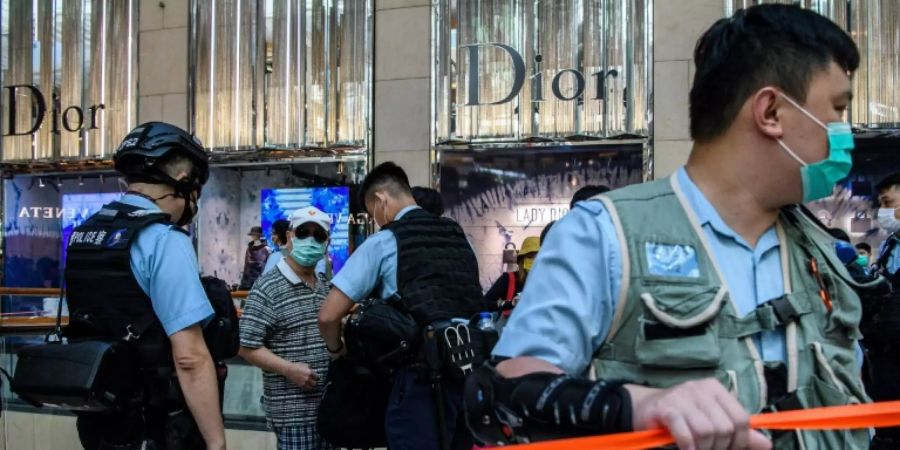 Polizisten durchsuchen Menschen in Hongkonger Einkaufszentrum