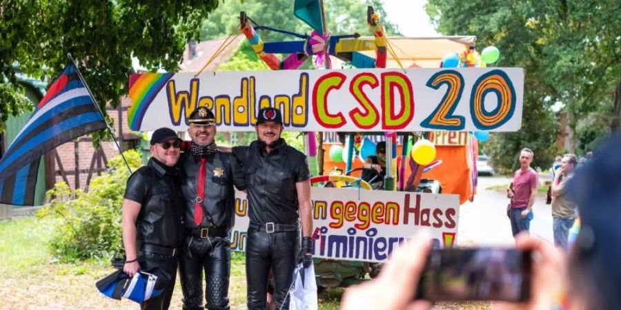 Teilnehmer der Parade Christopher Street Day (CSD) vor einem Trecker im Wendland. Foto: Philipp Schulze/dpa