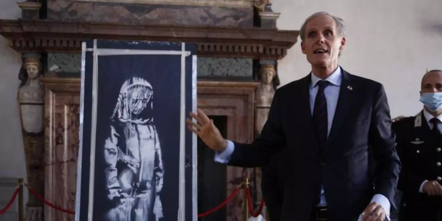 Christian Masset (l), Botschafter von Frankreich in Italien, neben der sogenannten Banksy-Tür in Rom. Foto: Domenico Stinellis/AP/dpa