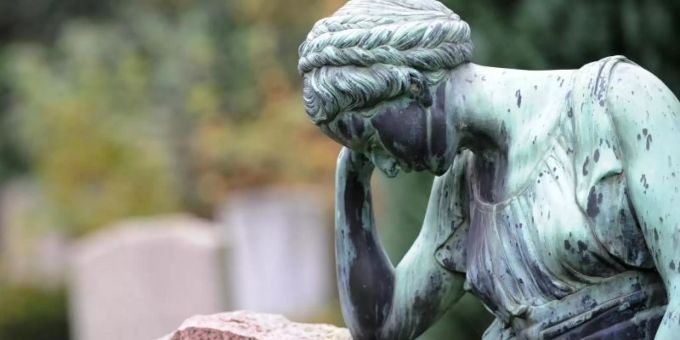 Eine Frauenfigur lehnt an einem Grabstein. Foto: picture alliance / dpa Eine Frauenfigur lehnt an einem Grabstein. Foto: picture alliance / dpa