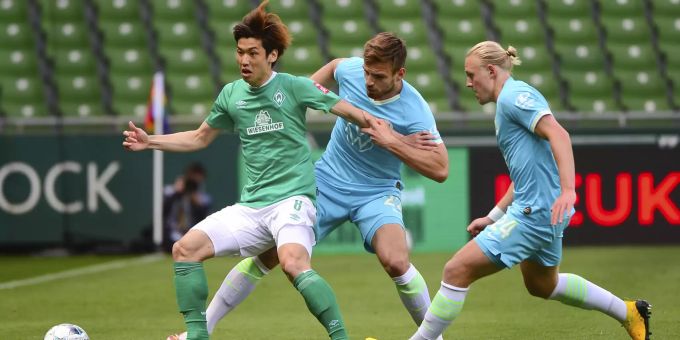 Yuya Osako (Werder Bremen) im Einsatz gegen Marin Pongracic und Xaver Schlager (beide VfL Wolfsburg) in der Bundesliga. Bundesliga Werder Bremen Wolfsburg