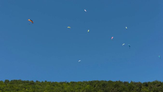 Farbenprächtige Gleitschirme am Himmel über Herbetswil.