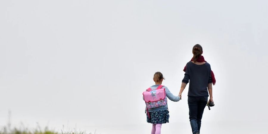 Frau mit einem Kind auf dem Weg zur Schule