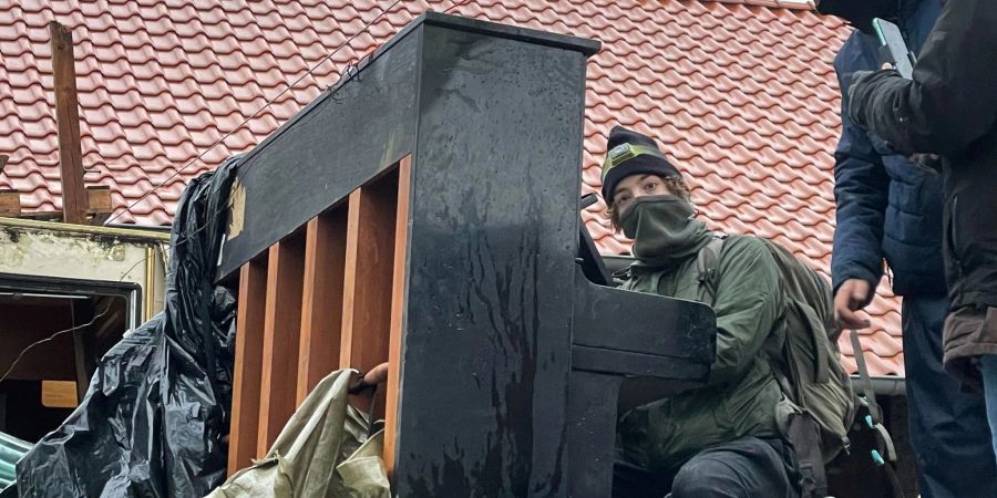 Ein Aktivist spielt Klavier, während die Polizei den besetzten Ort räumt.