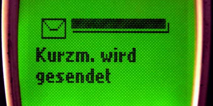 Auf dem Display eines alten Mobiltelefons steht «Kurzm. wird gesendet». sms