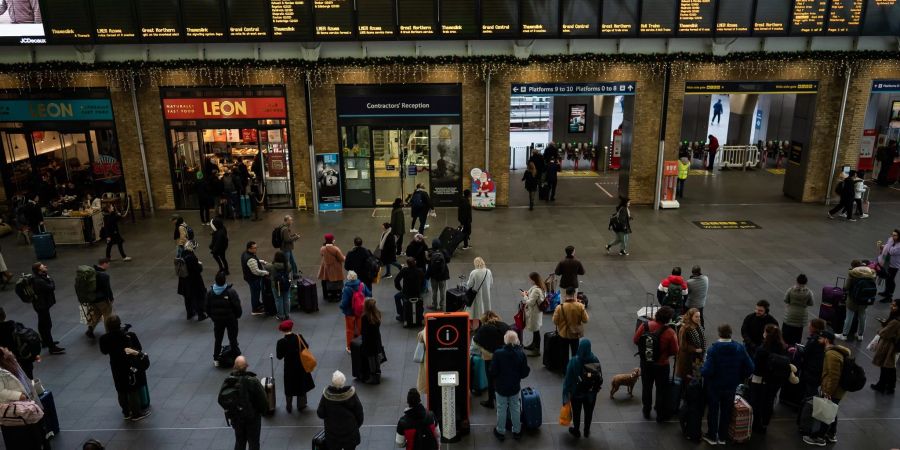 Menschen stehen an Anzeigetafeln im Londoner Bahnhof Kings Cross: Streiks behindern den Reiseverkehr zu Weihnachten erheblich.