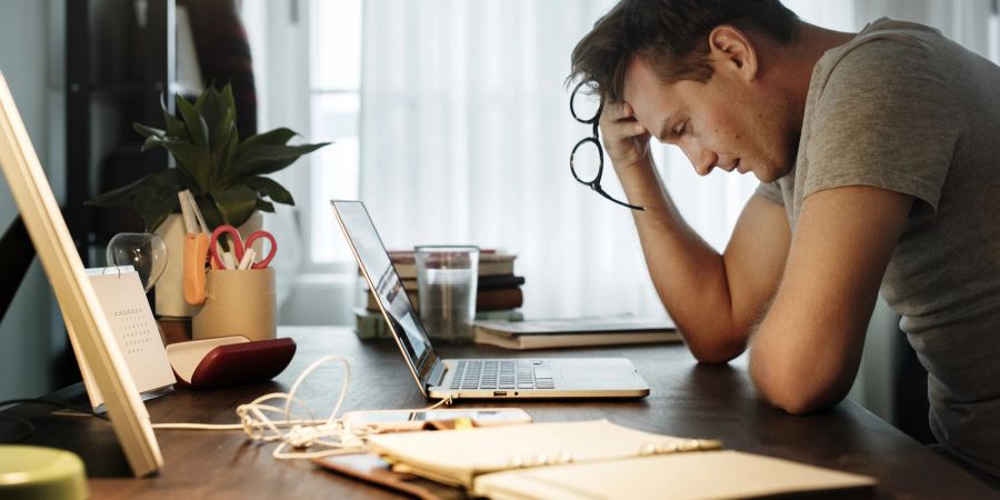 Mann sitzt angestrengt vor dem Laptop