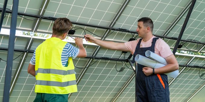 In der Schweiz besteht derzeit ein Mangel an Fachkräften auf dem Gebiet der Solarenergie. Männer Solar Modul Kabel