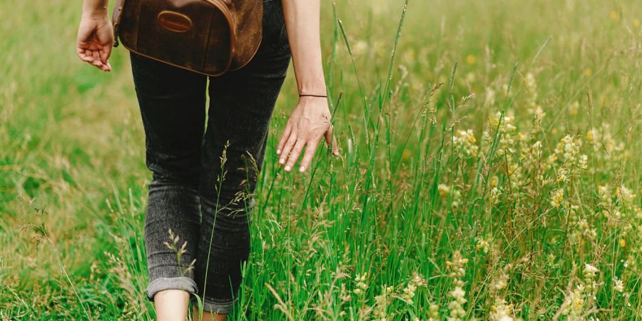 Frau mit Rucksack auf Wiese