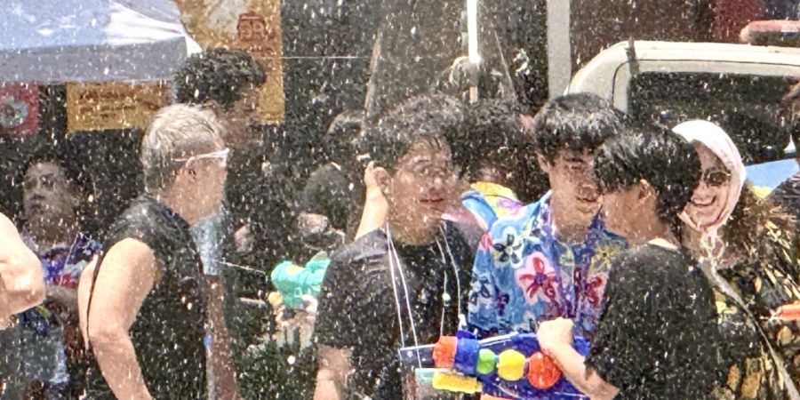 Menschen nehmen auf der Silom Road in Bangkok an einer Wasserschlacht teil. Foto: Carola Frentzen/dpa