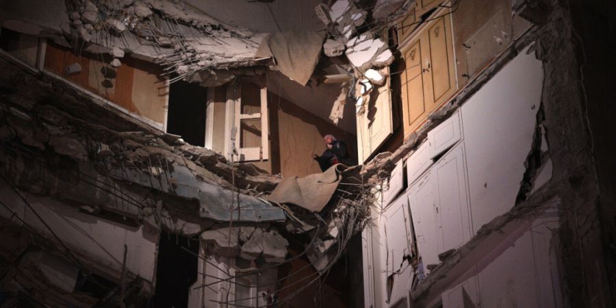 ARCHIV - Eine Frau, die einen israelischen Luftangriff überlebt hat, wartet darauf, aus einem zerstörten Gebäude im Zentrum von Beirut gerettet zu werden. Foto: Emilio Morenatti/AP/dpa