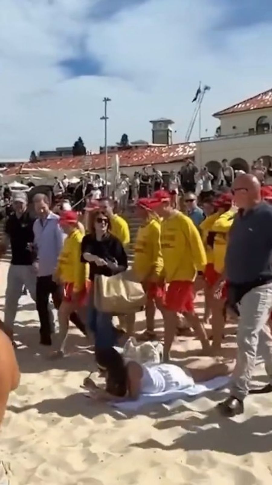 Kameras, Begleiter und Schaulustige drängen vorbei. Die Frau auf dem Tuch bleibt trotzdem seelenruhig.