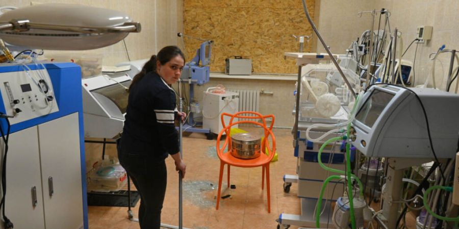 Eine Krankenschwester wischt Glascherben von zerbrochenen Fensterscheiben in einer Entbindungsklinik nach einem russischen Luftangriff in Odesa auf. Foto: Michael Shtekel/AP/dpa