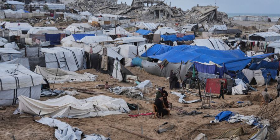 ARCHIV - Palästinenser inspizieren beschädigte Zelte in einem Vertriebenenlager im Gazastreifen. Foto: Jehad Alshrafi/AP/dpa/Archivbild