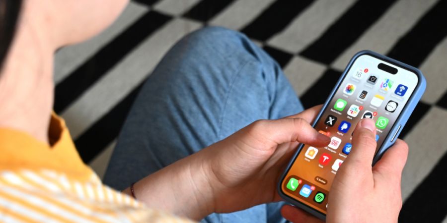 SYMBOLBILD - Eine Jugendliche sitzt auf dem Boden und nutzt ein Smartphone - auf dem Display sind verschiedene Apps zu sehen. Foto: Elisa Schu/dpa