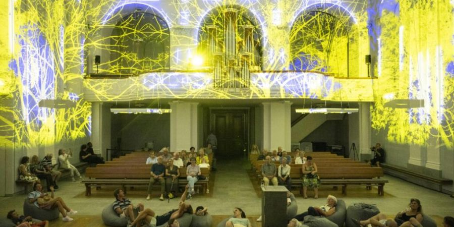 Menschen bestaunen die Lichtershow in der Reformierten Kirche am Volksfest Badenfahrt 2023. Die Zahl der Mitglieder der Reformierten Kirche im Aargau ist 2025 erneut zurückgegangen. (A...
