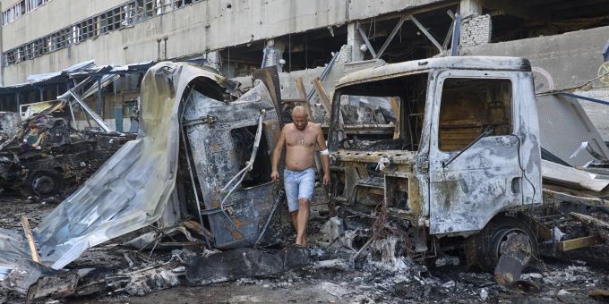 Ein Verletzter inspiziert beschädigte Autos am Ort eines Gleitbombenangriffs auf ein Postterminal in Charkiw, Nordostukraine, am 30. Juni 2024, inmitten der russischen Invasion. At least one killed, 10 injured after Russian glide bomb hit Kharkiv postal terminal