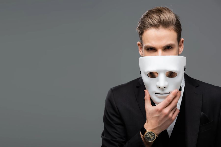 mann mit maske, grauer hintergrund, anzug