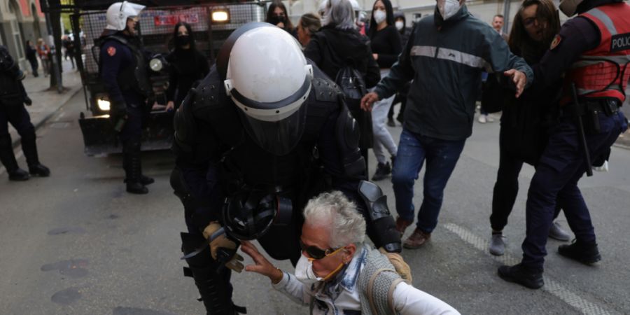 Ein Beamter der Bereitschaftspolizei versucht, einen Demonstranten während einer regierungskritischen Demonstration von der Straße zu bringen. Foto: Hameraldi Agolli/AP/dpa
