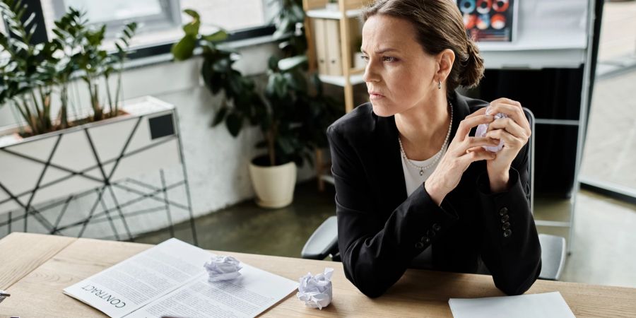 Frau am Schreibtisch kann sich nicht konzentrieren.