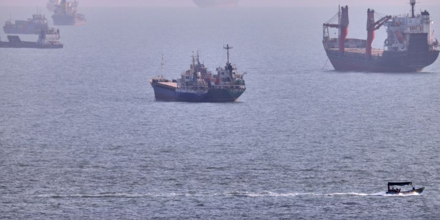 Ein kleines Boot segelt an Frachtschiffen und anderen Handelsschiffen in der Straße von Hormus vorbei. Foto: Amirhosein Khorgooi/ISNA/AP/dpa/Archivbild
