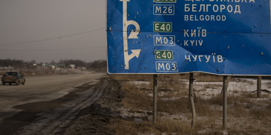 ARCHIV - Ein Auto fährt an einem beschädigten Straßenschild auf der Straße zur russischen Stadt Belgorod vorbei. Foto: Vadim Ghirda/AP/dpa