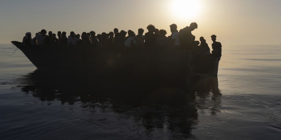 ARCHIV - Migranten sitzen in einem Holzboot, während sie von Freiwilligen des Rettungsschiffs «Ocean Viking» gerettet werden. Foto: Jeremias Gonzalez/AP/dpa/Archivbild