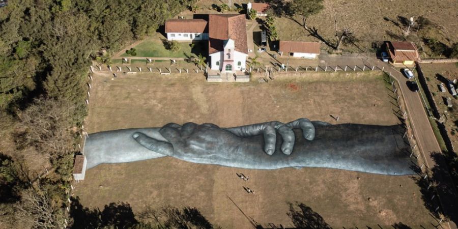 Ein riesiges Kunstwerk des französischen Künstlers Saype auf dem Fussballplatz Corrego do Feijao zu Ehren der Opfer und Geschädigten des Dammbruchs von Vale S.A., der sich am 25. Januar 2019 ereignete. Foto: Rodney Costa/ - ACHTUNG: Nur zur redaktionellen Verwendung im Zusammenhang mit der aktuellen Berichterstattung und nur mit vollständiger Nennung des vorstehenden Credits