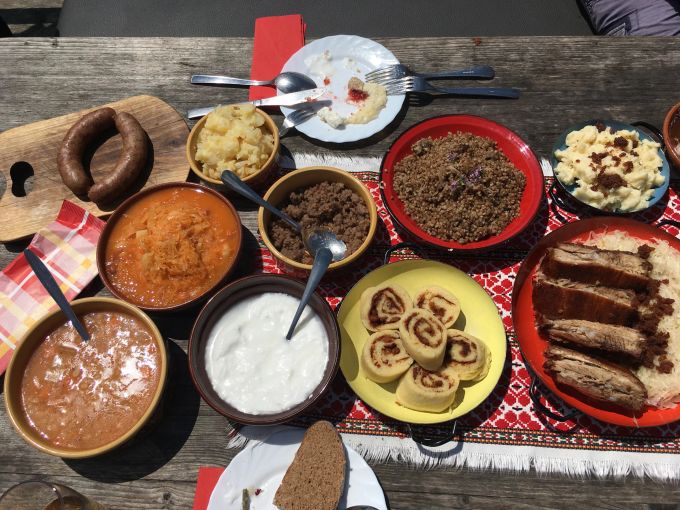 Sterz, Quarkstrudel, Braten und mehr: So sieht es aus, wenn auf der Velika planina traditionell aufgetischt wird. Tisch Holz Töpfe Gerichte Strudel Fleisch Braten