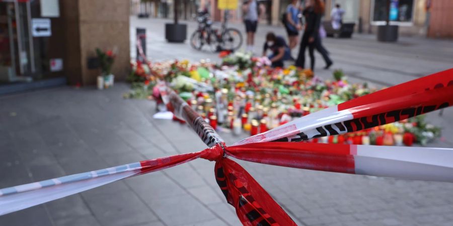 Blumen und Kerzen vor dem abgesperrten Kaufhaus, wo ein Mann Menschen mit einem Messer attackiert hatte.