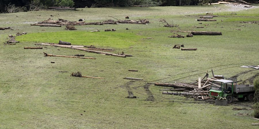 Ein Bauer räumt am Dienstag auf einem Bumbacher Feld von der Emme abgelagertes Holz weg.