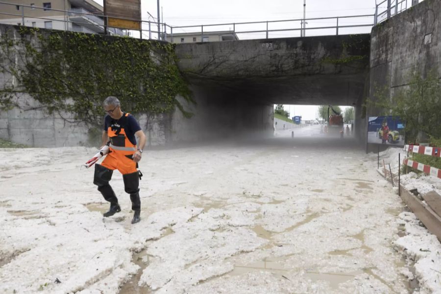 Eine Strasse, die unter einer Brücke hindurchführt, wurde nach einem heftigen Regenschauer am Montag, 28. Juni 2021, in Bulle FR unpassierbar gemacht.