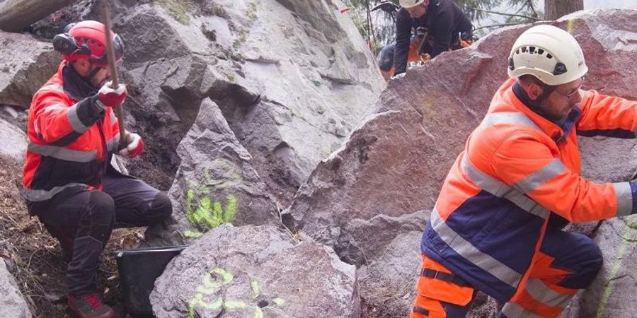 Einsatzkräfte bereiten die Sprengung eines grossen Felsbrockens im Höllental vor. Der Klotz wiegt bis zu 60 Tonnen. Foto: Thomas Reichelt/dpa