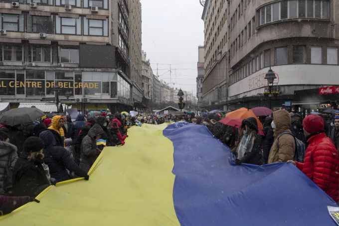 Demonstranten halten eine grosse ukrainische Fahne in den Händen während einer Kundgebung gegen den von Russland ausgelösten Ukraine-Krieg. Ukraine Krieg Belgrad Demo