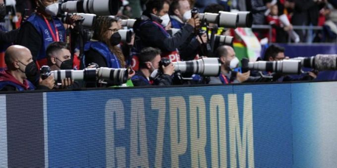 Bei einem Spiel der Champions League stehen Fotoreporter hinter einer Bande mit dem Schriftzug von Gazprom. Foto: Manu Fernandez/AP/dpa Bei einem Spiel der Champions League stehen Fotoreporter hinter einer Bande mit dem Schriftzug von Gazprom. Foto: Manu Fernandez/AP/dpa