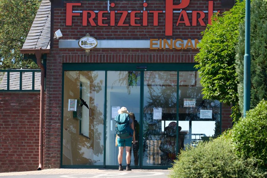 Eine Frau steht vor dem geschlossenen Eingang des Parkes.
