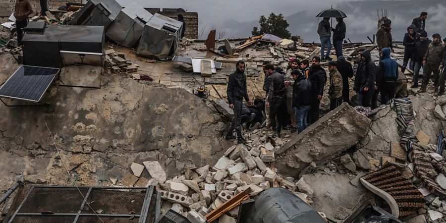 Syrische Zivilisten inspizieren ein zerstörtes Wohnhaus nach einem Erdbeben der Stärke 7,8 in Syrien.