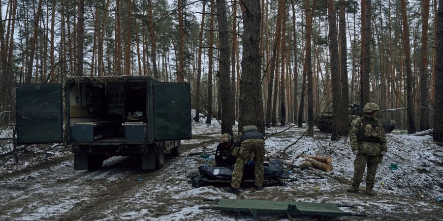 Militärsanitäter legen die Leiche eines in einem Gefecht in Kremenna getöteten Soldaten in einen Leichensack.